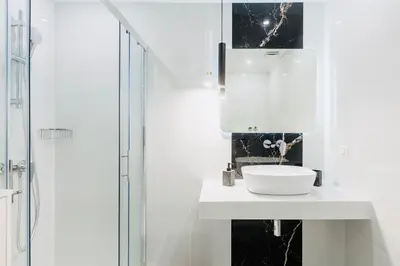 a white bathroom with a sink and a shower at Hidden Treasure of Koukaki in Athens