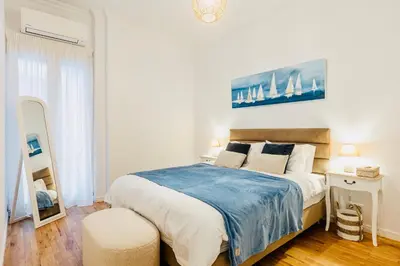 a bedroom with a large bed with a blue blanket at Hidden Treasure of Koukaki in Athens