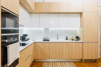 a kitchen with white countertops and wooden cabinets at Hidden Treasure of Koukaki in Athens