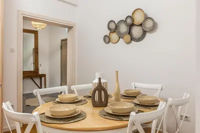 a dining room with a table with plates and bowls at Hidden Treasure of Koukaki in Athens
