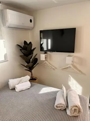 a bedroom with a bed with towels and a flat screen tv at Athena 2 in Athens