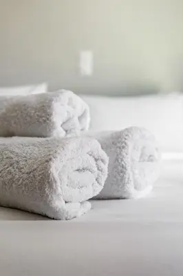 a pile of white towels sitting on a bed at Cutie Studio Apartment in Koukaki in Athens