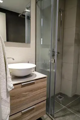 a bathroom with a sink and a glass shower at Cutie Studio Apartment in Koukaki in Athens