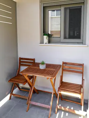 a table and two chairs sitting next to a window at Cutie Studio Apartment in Koukaki in Athens