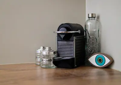 a bottle of water and a small appliance on a table at Cutie Studio Apartment in Koukaki in Athens