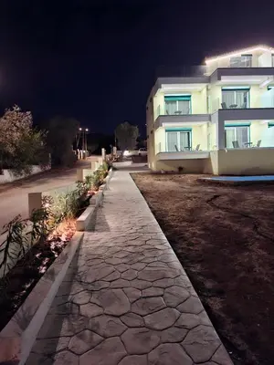 a stone walkway in front of a building at night at AIR-IN Rooms with magnificent views in Spáta