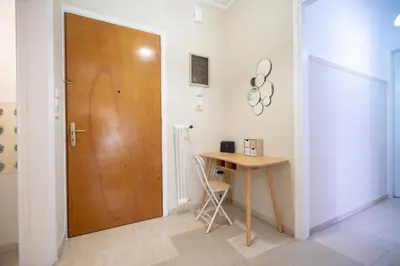 a wooden door in a room with a table and a desk at Neos Kosmos metro st 1 bedrm 3 pers flat by MPS in Athens