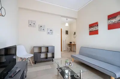 a living room with a blue couch and a table at Neos Kosmos metro st 1 bedrm 3 pers flat by MPS in Athens