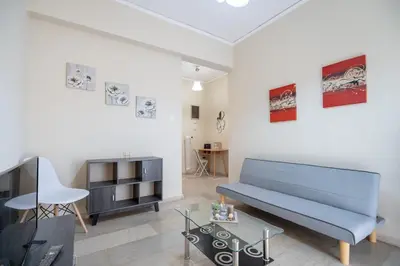 a living room with a blue couch and a tv at Neos Kosmos metro st 1 bedrm 3 pers flat by MPS in Athens