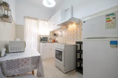 a small kitchen with white appliances and a table at Neos Kosmos metro st 1 bedrm 3 pers flat by MPS in Athens