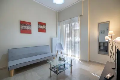 a living room with a blue couch and a glass table at Neos Kosmos metro st 1 bedrm 3 pers flat by MPS in Athens