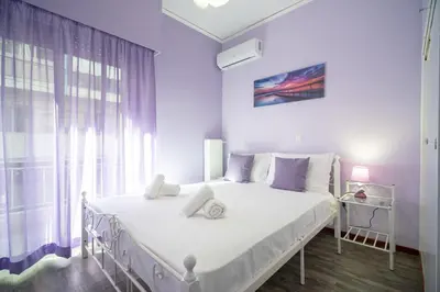 a white bed in a room with a large window at Neos Kosmos metro st 1 bedrm 3 pers flat by MPS in Athens