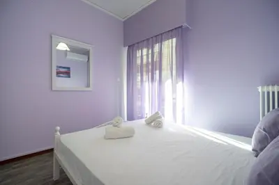 a white bedroom with a bed with two towels on it at Neos Kosmos metro st 1 bedrm 3 pers flat by MPS in Athens