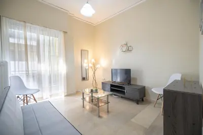 a living room with a tv and a table at Neos Kosmos metro st 1 bedrm 3 pers flat by MPS in Athens