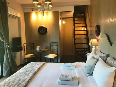 a bedroom with a large bed with towels on it at Villa Vravrona Tower & Suites in Markopoulo