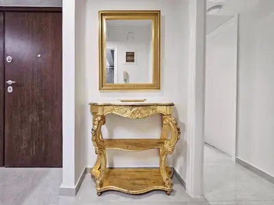a gold console table in a hallway with a mirror at Athens Prestige Suite Apartment in Athens
