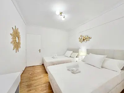 a white bedroom with two beds in it at Athens Prestige Suite Apartment in Athens