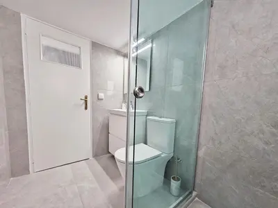 a bathroom with a toilet and a glass shower at Athens Prestige Suite Apartment in Athens