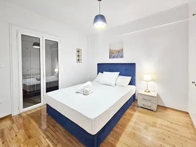 a white bedroom with a large bed and a window at Athens Prestige Suite Apartment in Athens