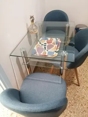 a glass table with two blue chairs and a glass table with a glass chair at 8' από Μετρό,Ντυνάν,Παίδων,Λαϊκό in Athens