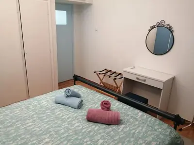 a bedroom with a bed with two pillows and a mirror at 8' από Μετρό,Ντυνάν,Παίδων,Λαϊκό in Athens