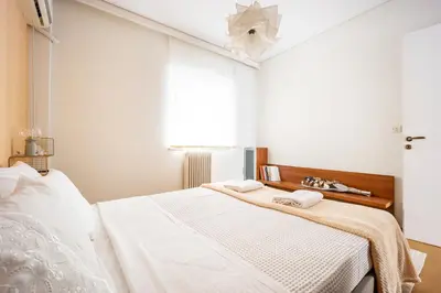 a white bedroom with a bed with two towels on it at Group&Family Luxury in Athens
