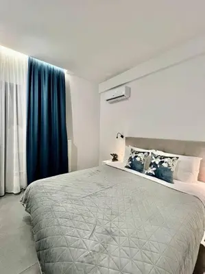 a bedroom with a large bed with blue curtains at Cozy apartment in a new building apartment 5 in Piraeus