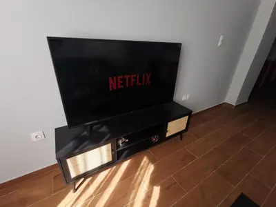 a flat screen tv sitting on a entertainment center at Athens Oasis Apartment in Athens