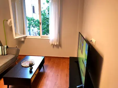 a living room with a couch and a tv and a table at Athens Oasis Apartment in Athens