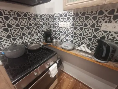 a kitchen with black and white tiles on the wall at Athens Oasis Apartment in Athens