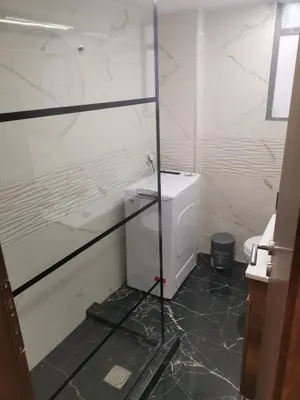 a bathroom with a toilet and a glass wall at Athens Oasis Apartment in Athens