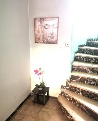 a painting of a face on the wall next to a staircase at Athens Oasis Apartment in Athens