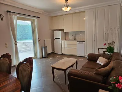a living room with a couch and a table at Guest apartment within a villa in Lagonissi in Kalívia Thorikoú