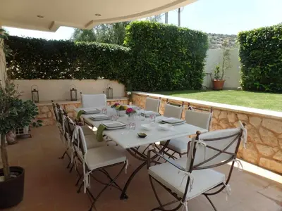 a white table and chairs on a patio at Guest apartment within a villa in Lagonissi in Kalívia Thorikoú