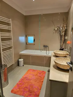 a bathroom with two sinks and a bath tub at Guest apartment within a villa in Lagonissi in Kalívia Thorikoú