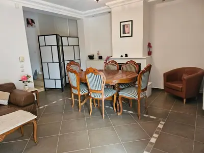 a dining room with a wooden table and chairs at Guest apartment within a villa in Lagonissi in Kalívia Thorikoú