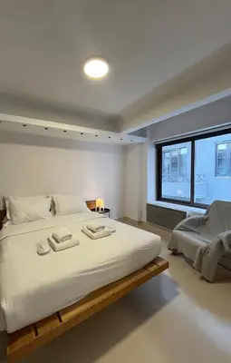 a bedroom with a large white bed with a window at Mosaikon Guesthouses #Vasilikis Str in Athens