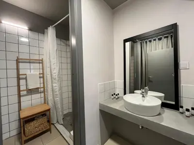 a white bathroom with a sink and a shower at Mosaikon Guesthouses #Vasilikis Str in Athens