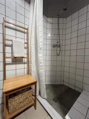a bathroom with a shower with a bench and a shower curtain at Mosaikon Guesthouses #Vasilikis Str in Athens