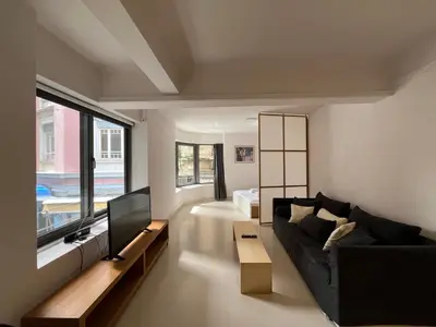 a living room with a black couch and a tv at Mosaikon Guesthouses #Vasilikis Str in Athens
