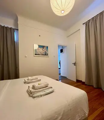 a bedroom with a bed with two towels on it at Mosaikon Guesthouses #Miltiadou Str in Athens