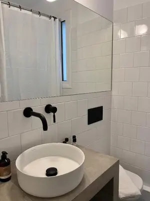 a white bathroom with a sink and a mirror at Mosaikon Guesthouses #Miltiadou Str in Athens