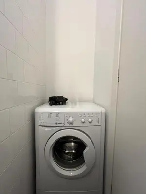 a washing machine with a black cat sitting on top of it at Mosaikon Guesthouses #Miltiadou Str in Athens