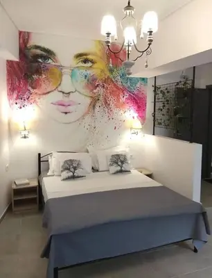 a bedroom with a large mural of a woman at Ifaistos Luxury flat Psyrri square in Athens