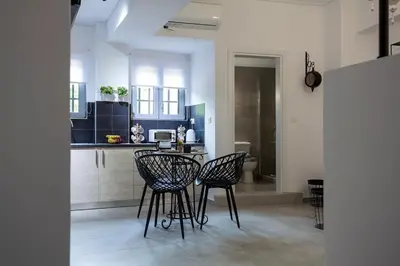 a kitchen with two black chairs and a counter at Ifaistos Luxury flat Psyrri square in Athens