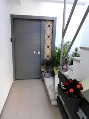 a door to a building with flowers and stairs at Ifaistos Luxury flat Psyrri square in Athens