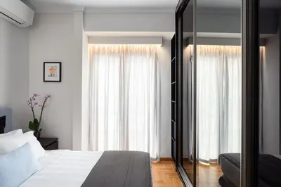 a bedroom with a bed and a large window at Acropolis Vibe Residence in Athens