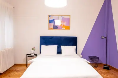 a bedroom with a large bed with a blue headboard at Agora Apartment Plaka and Acropolis area in Athens