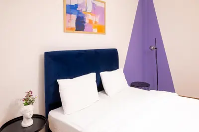 a bedroom with a bed with a blue headboard at Agora Apartment Plaka and Acropolis area in Athens