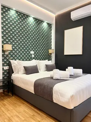 a bedroom with a large bed in a room with a wall at Acropolis Golden View Penthouse in Athens